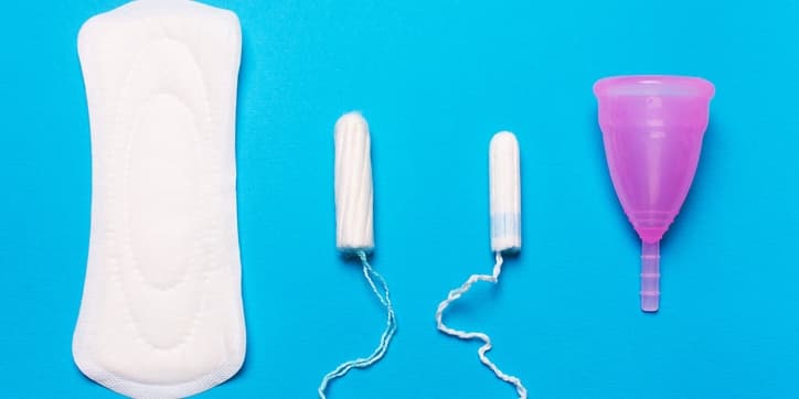 Pad, menstrual cup, tampon on a blue background.