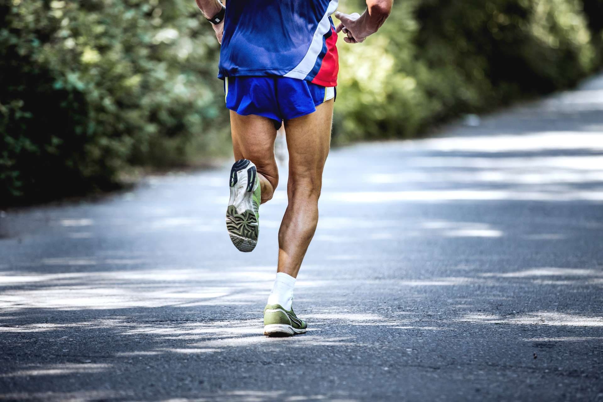 Tscheljabinsk, Russland - 9. Juli 2016: Fuß alter männlicher Athlet läuft auf Straße im Wald während des Sommerhalbmarathons