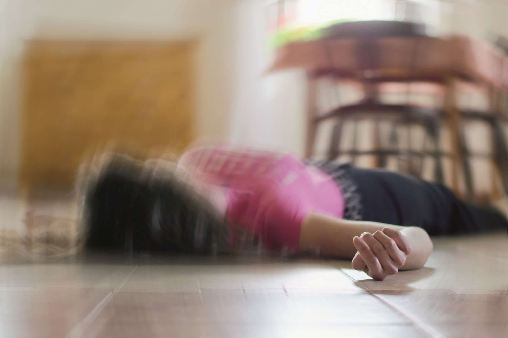 Frau, die zu Hause auf dem Boden liegt, Epilepsie, Bewusstlosigkeit, Ohnmacht, Schlaganfall, Unfall oder anderes Gesundheitsproblem.