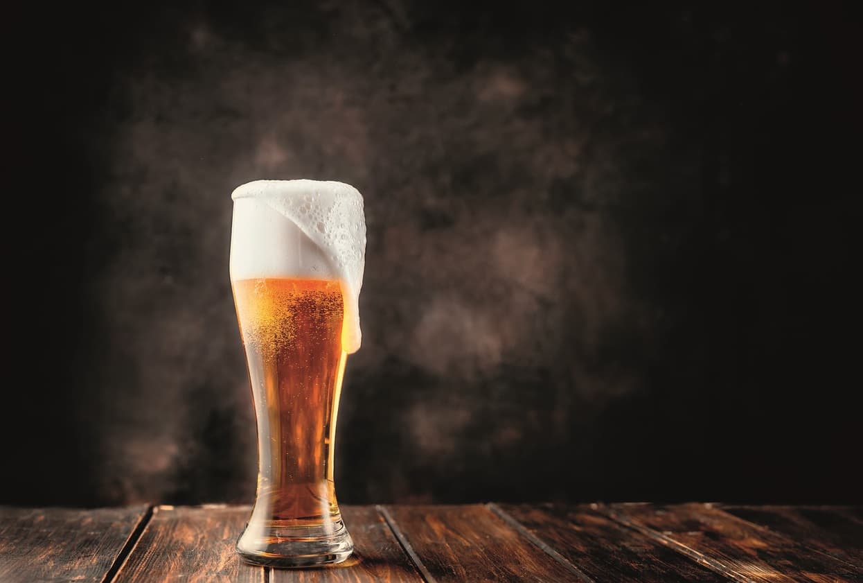 Glas frisches und kaltes Bier auf dunklem Hintergrund. Speicherplatz kopieren.