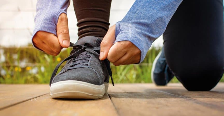 Ein junger Mann schnürte seine Schuhe vor einem Lauf am frühen Morgen