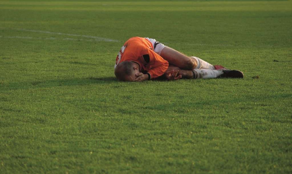 Fussballer liegt am Boden