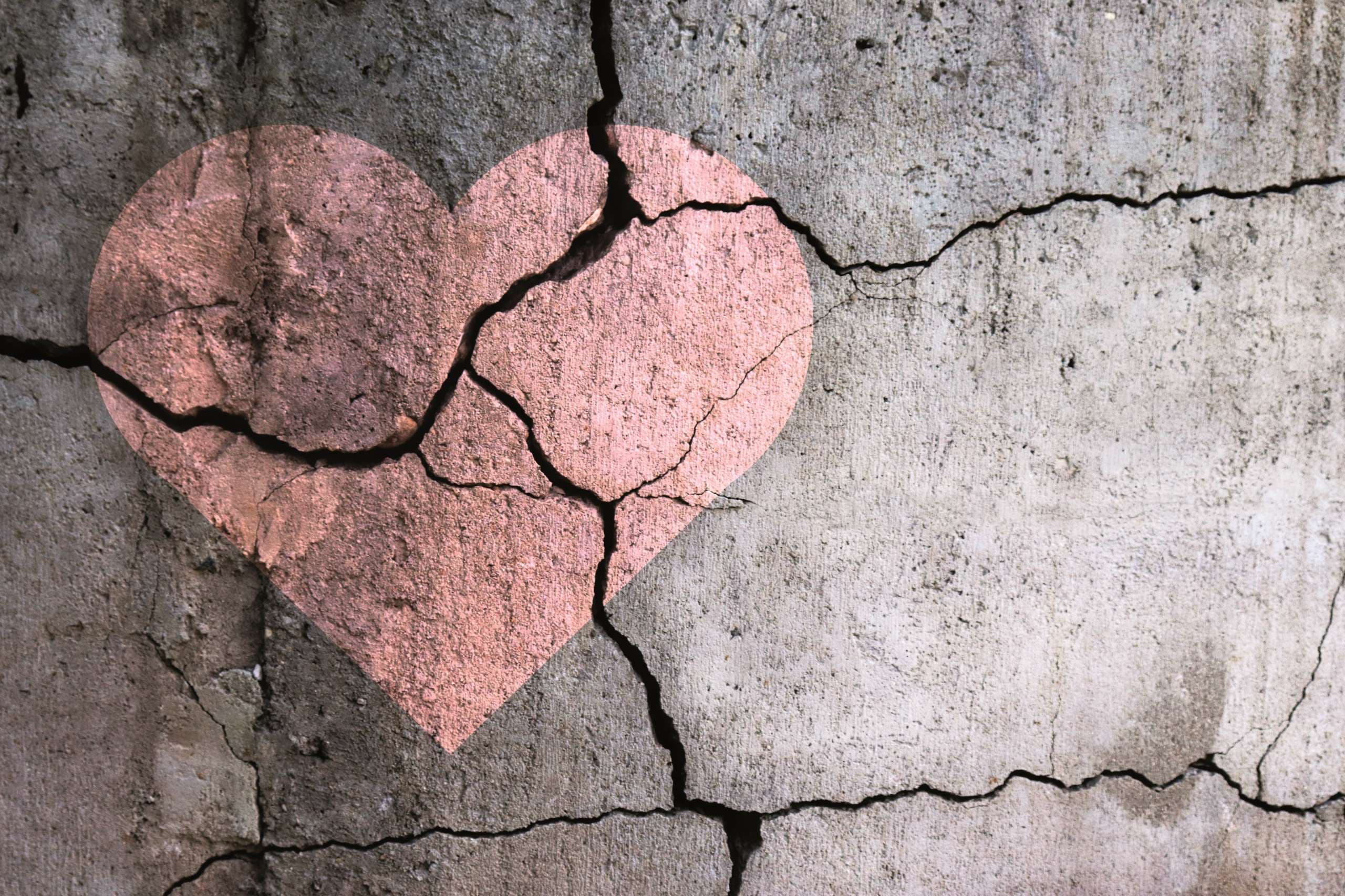 A broken heart. Drawing of a heart on a cracked wall. Broken relationships. Treason and betrayal. Past love. A quarrel.