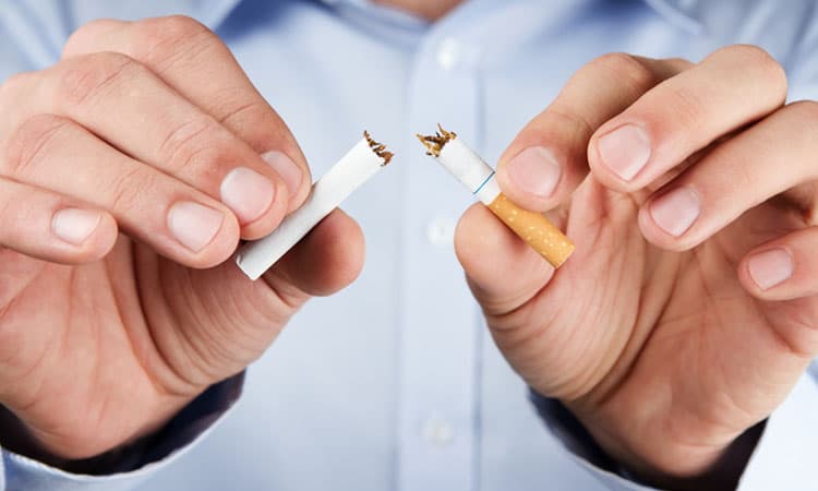 Human hands breaking cigarette