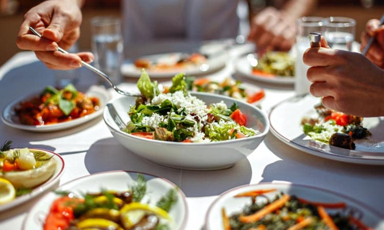 Couple  Eating Lunch with Fresh Salad and Appetizers