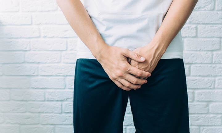 man wearing shorts holding genitals. Men's health, venereologist, sexual disease