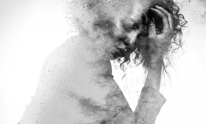Subtle woman's form in an unhappy pose double exposed with a monochromatic paint splatter photographic effect