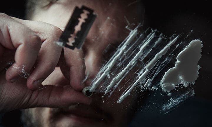 Man snorting cocaine in dark room. Drug addict concept.