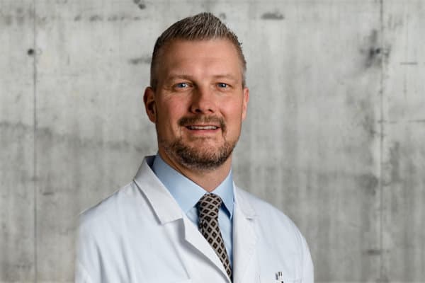 Portraitfoto Prof. Matthias Zumstein vor Betonwand