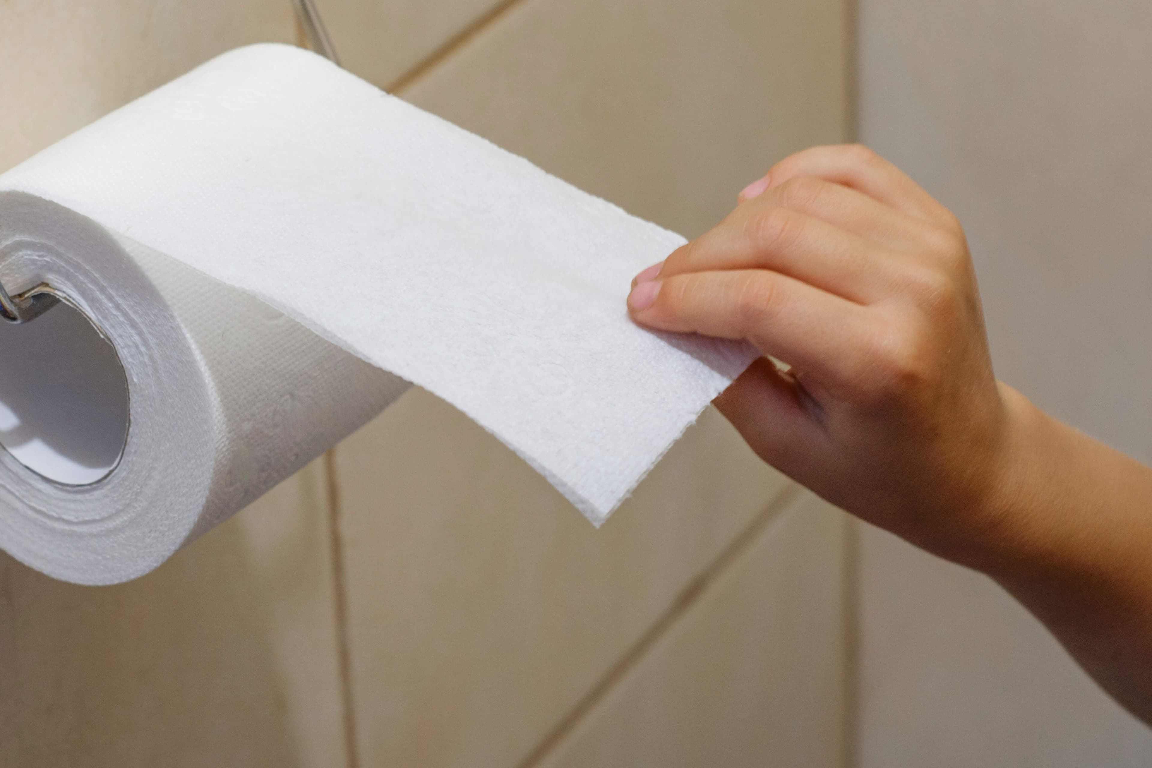 Ein Kind reißt Toilettenpapier ab. Verdauungsstörungen bei Kindern