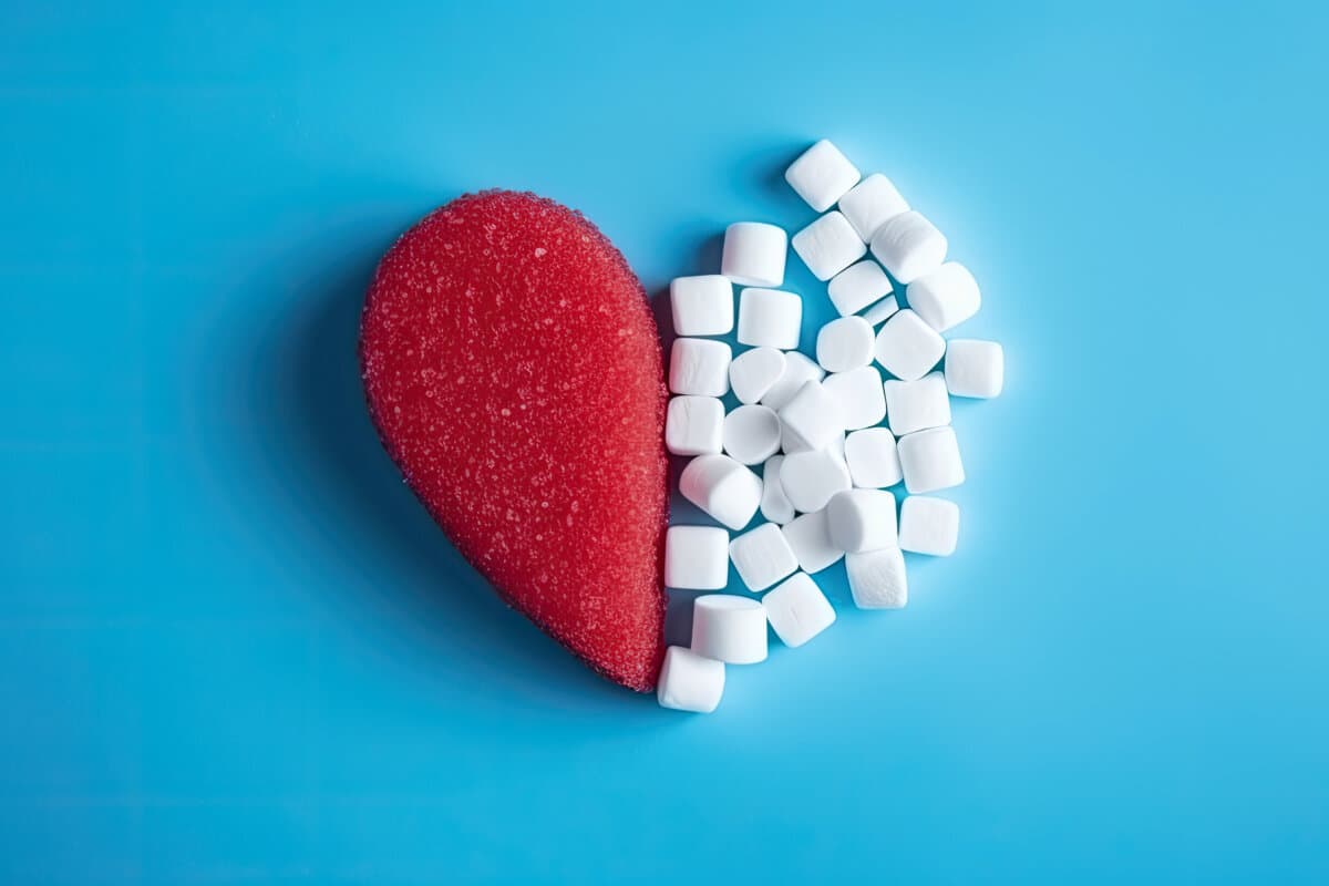A heart making of half a red heart and sugar cubes on a blue background. World diabetes day, November 14.
