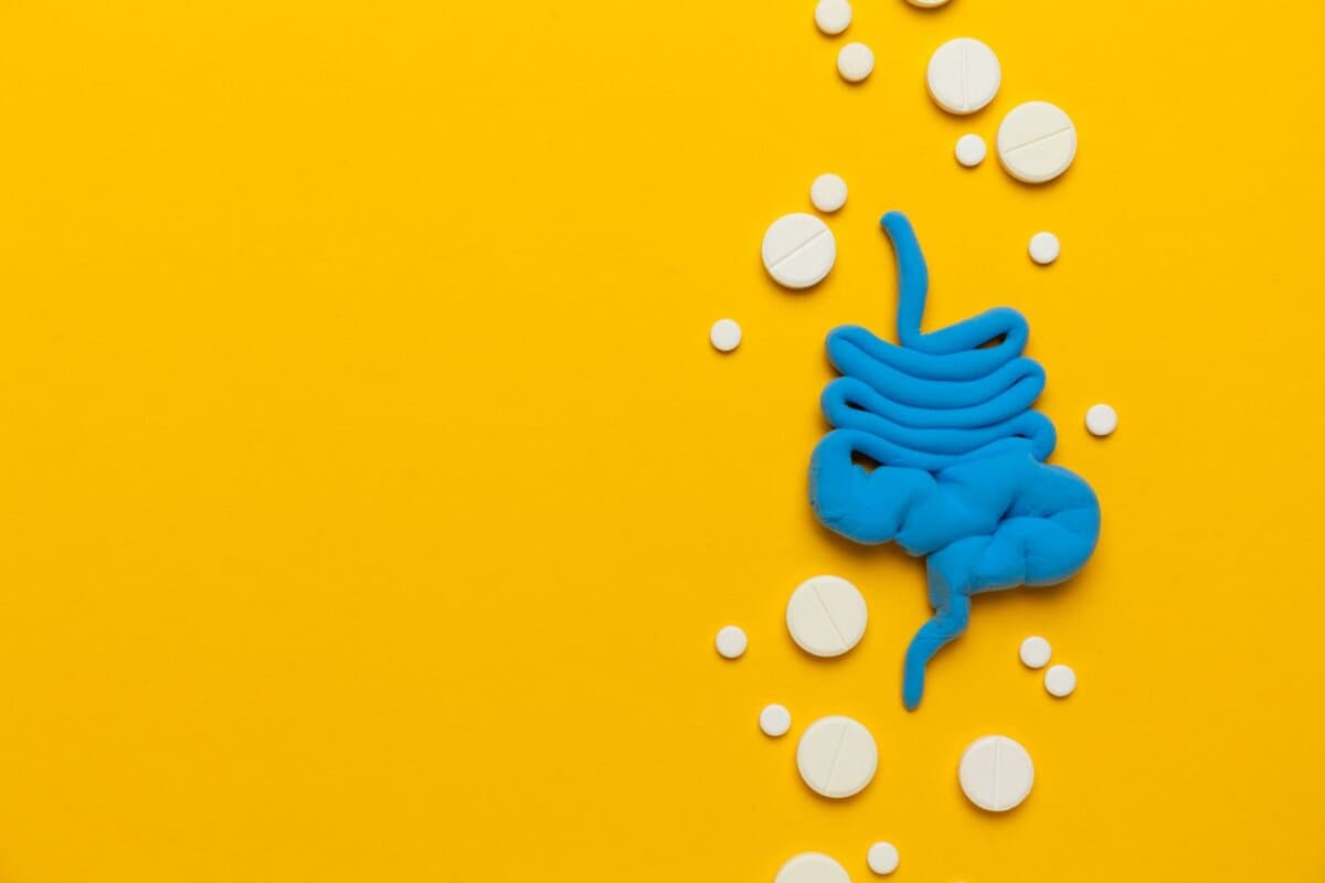Intestins humains avec des pilules sur fond jaune. Diarrhée et constipation. Pointes et maux d'estomac.