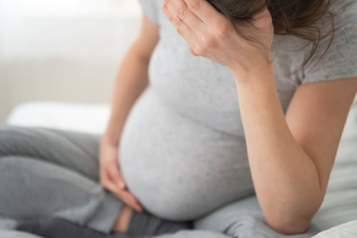 Schwangerschaft, Stress, Frau hält sich den Kopf