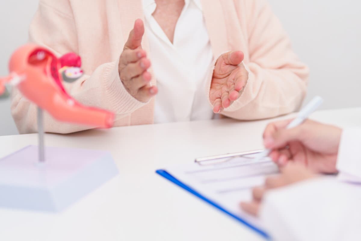 Eine ältere Patientin konsultiert einen Arzt bezüglich der Anatomie von Gebärmutter und Eierstöcken.