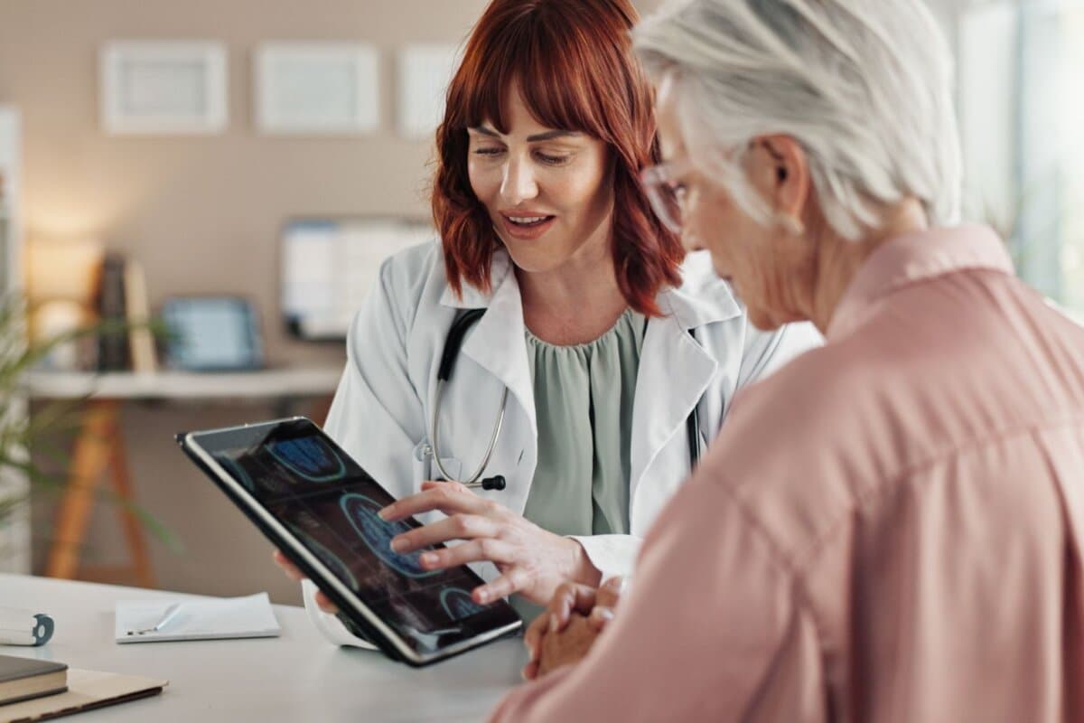 Tablet, Arzt und ältere Frau mit Ergebnissen einer Gehirnscan-Untersuchung, Beratung oder Gesundheitsgespräch in der