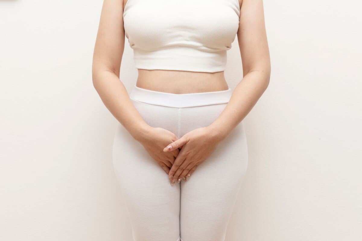 Frau hält Hände vor den Intimbereich