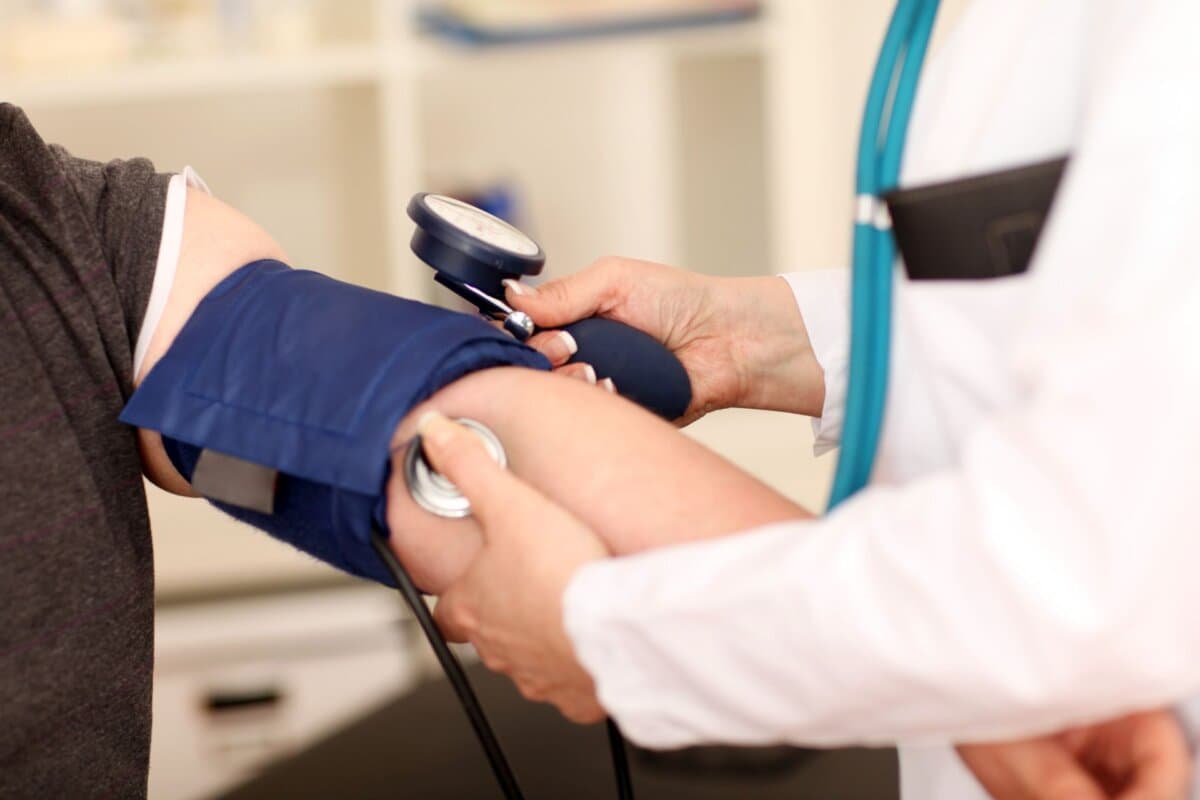 Arzt misst bei einem Patienten den Blutdruck.