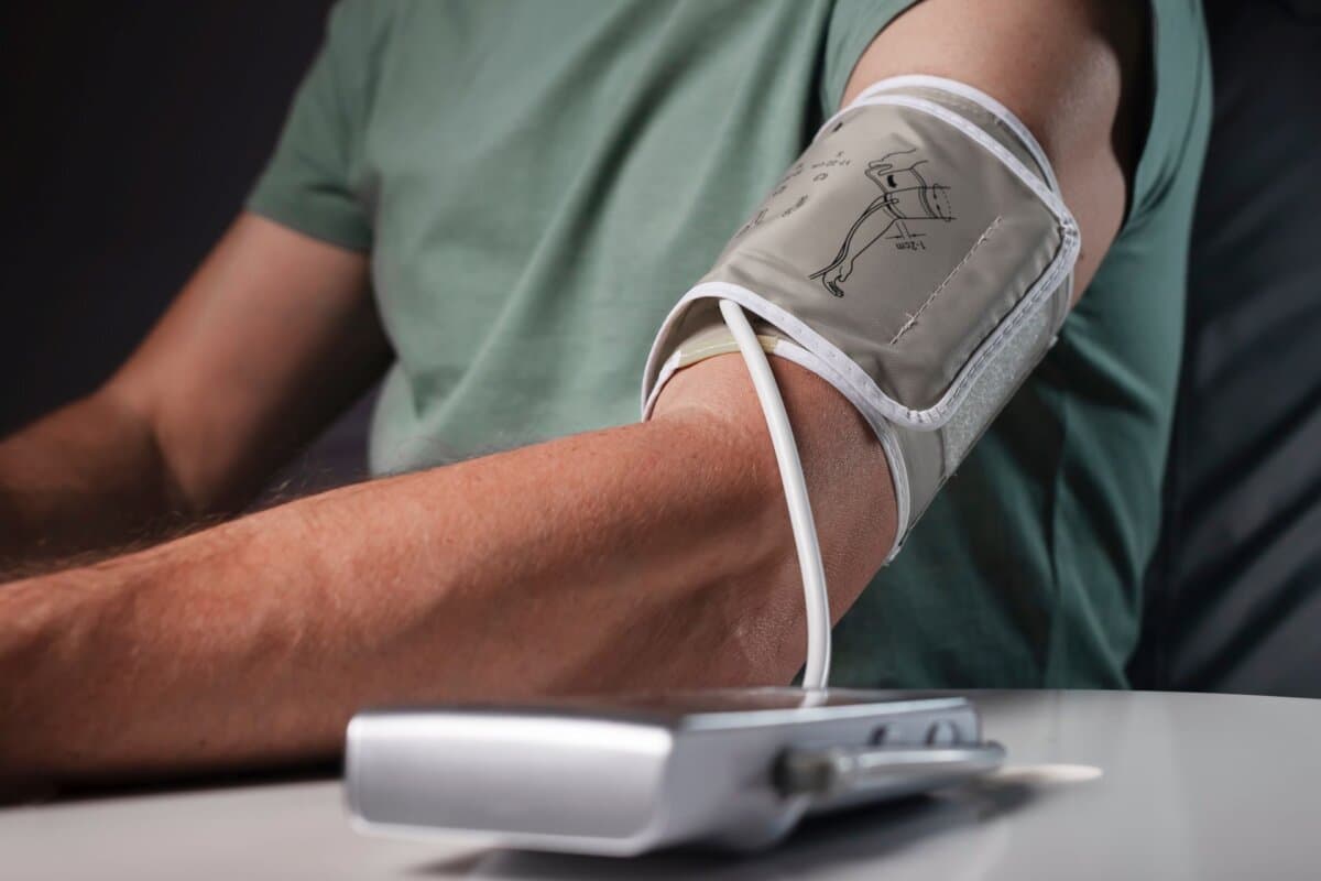 Ein Mann misst seinen Blutdruck mit einer modernen Manschette zur häuslichen Kontrolle.