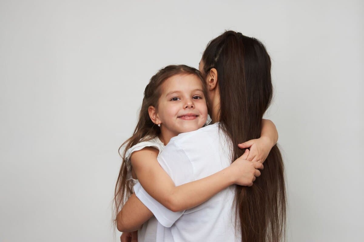 Glückliche Mutter mit ihrer 5–6-jährigen Tochter beim gemeinsamen Spiel.