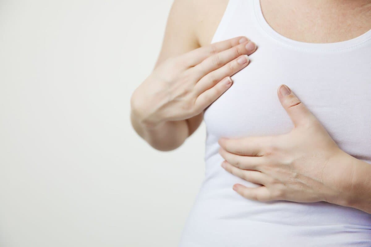 Frau untersucht ihre Brust im Rahmen der Selbstkontrolle.