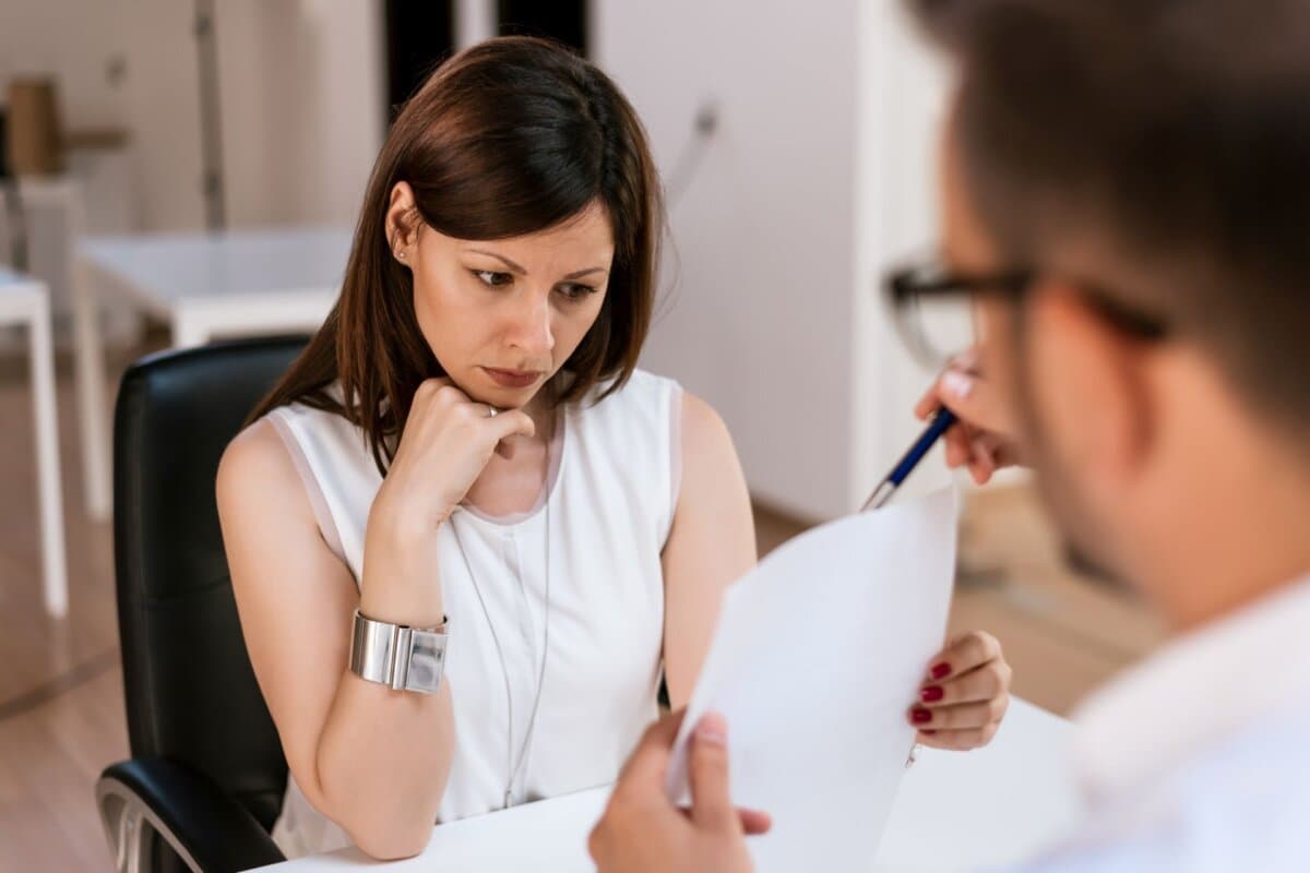 Beratungsgespräch zwischen Arzt und besorgter Patientin in der Praxis.