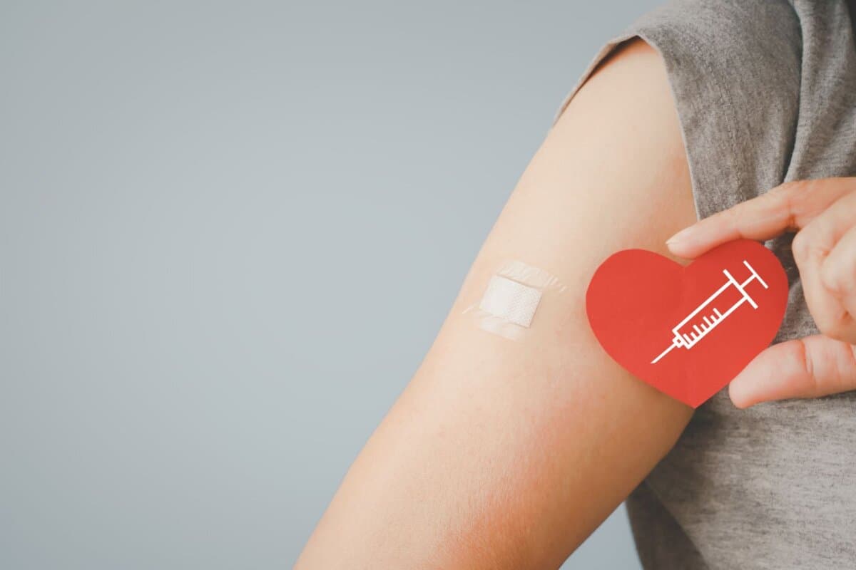 Influenza-Impfung im Fokus: Seniorin mit Herzsymbol – Schutz vor Grippe kann auch das Herz entlasten.