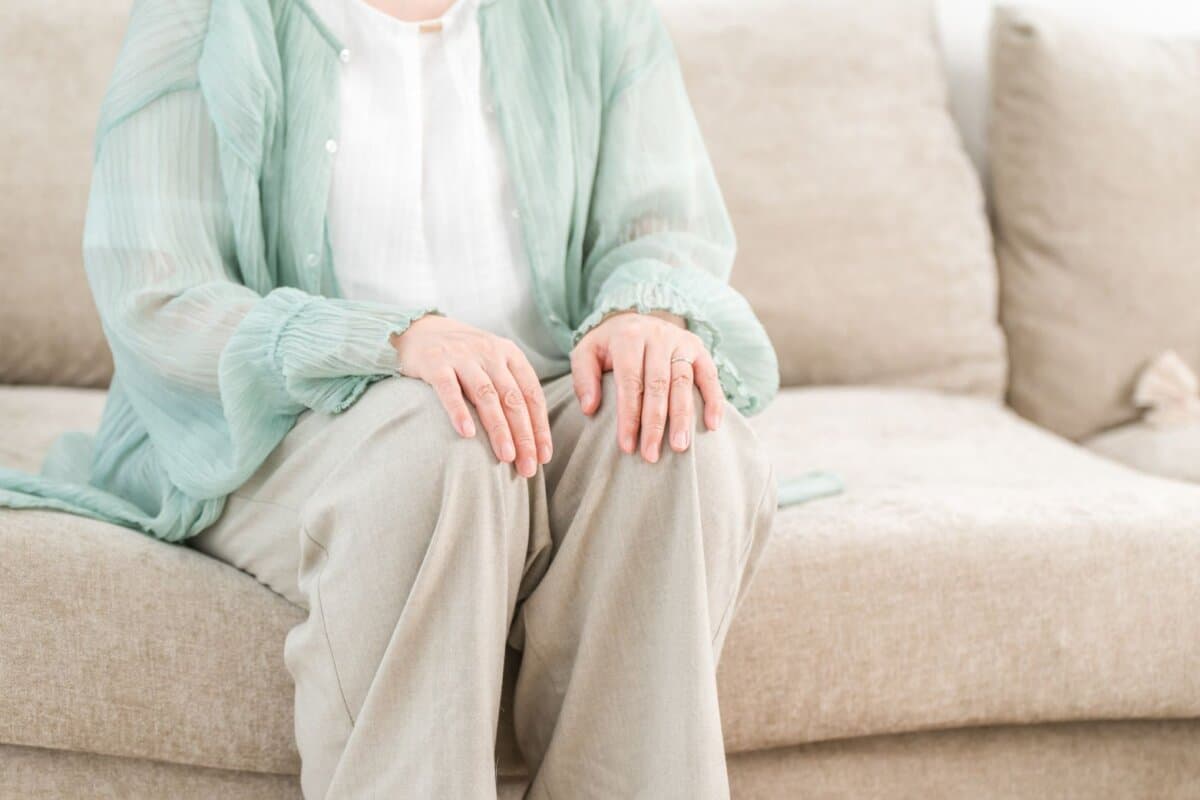 Ältere Frau entspannt auf dem Sofa im Wohnzimmer.