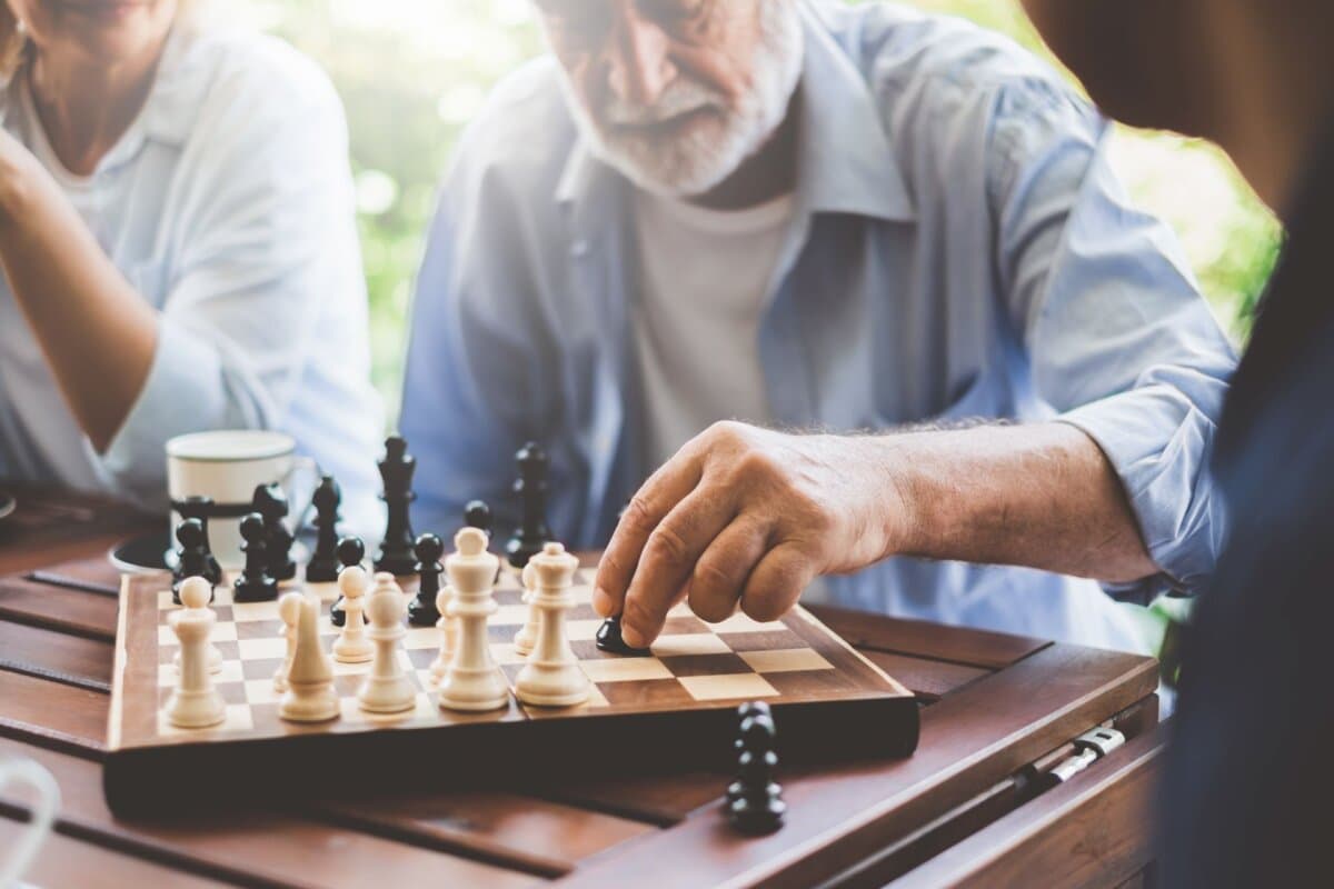 Älterer Mann spielt Schach – Symbol für strategisches Denken und kognitive Aktivität.