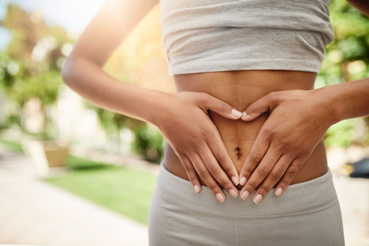 Frau hält sich Hände auf den Bauch.