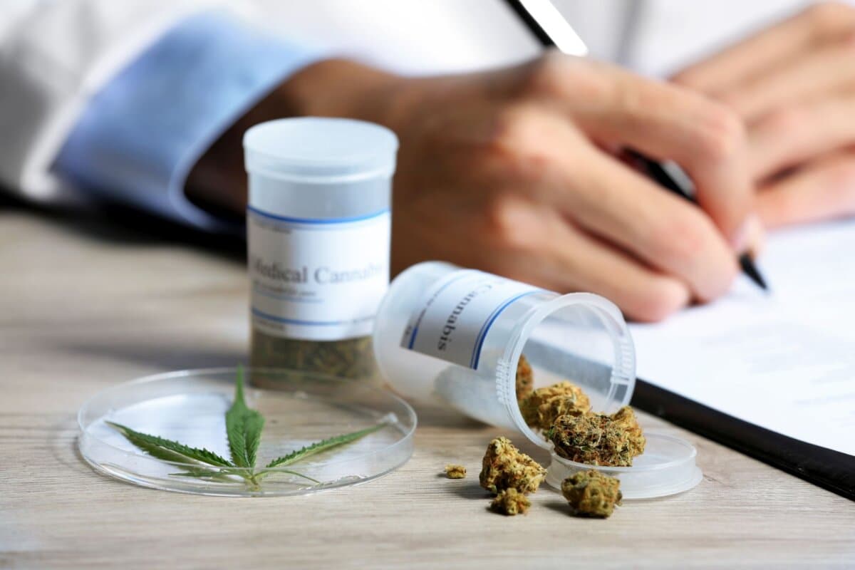 Arzt stellt ein Rezept für medizinisches Cannabis aus; Cannabisarznei und Verordnungsunterlagen im Fokus.