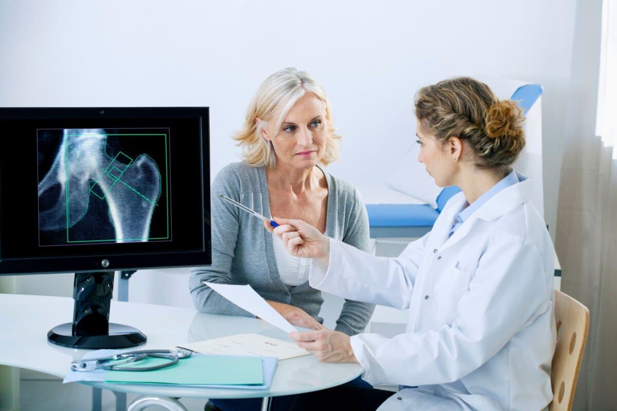 Ärztin bespricht eine Osteodensitometrie mit einer Patientin