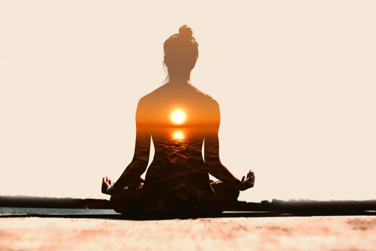 Frau übt Yoga im Sonnenuntergang