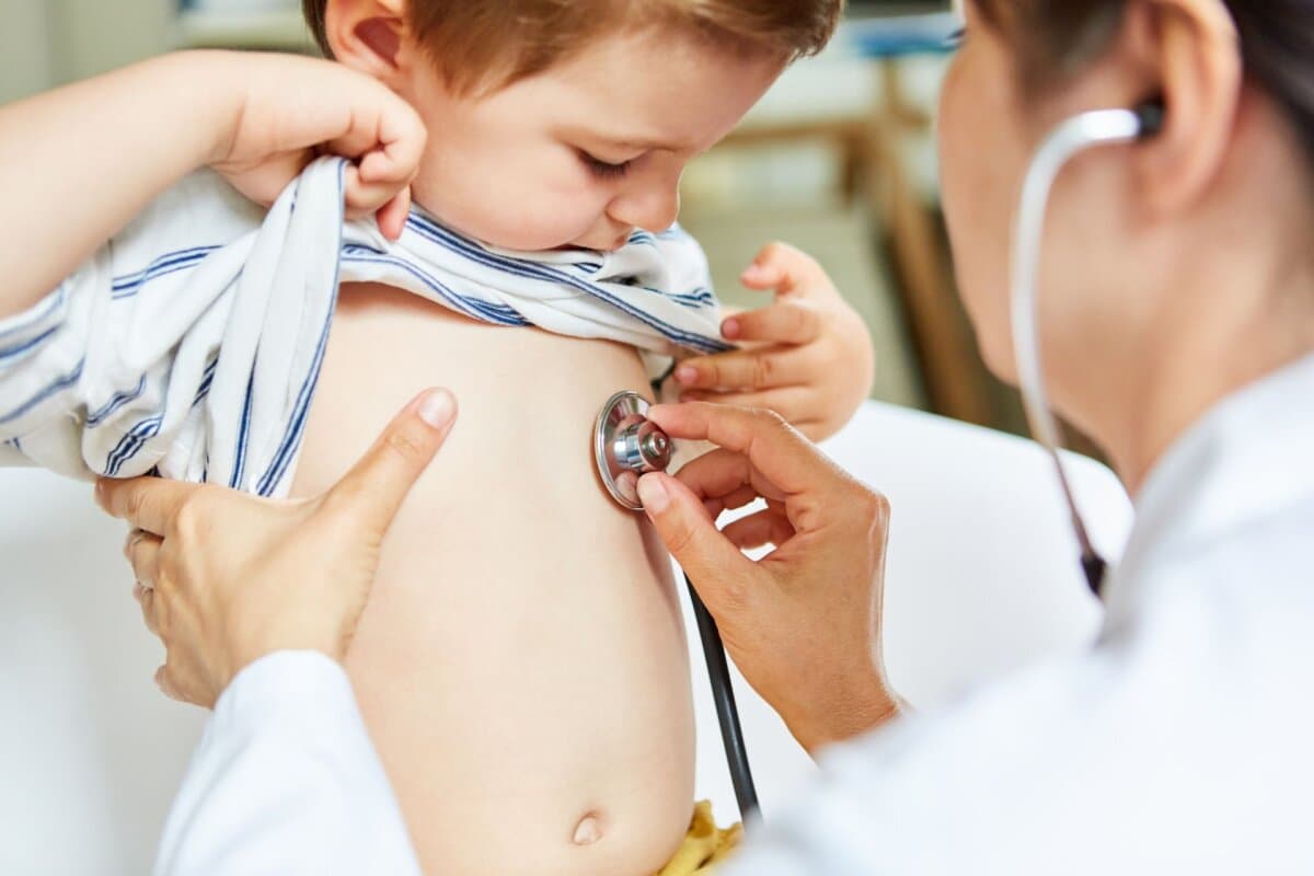 Kinderärztin beim Abhören einer Lunge vom Kind mit Stethoskop