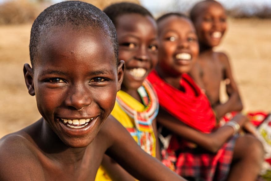 Vier afrikanische Kleinkinder sitzen nebeneinander