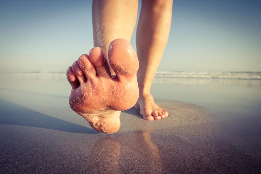Füsse laufen am Strand entlang