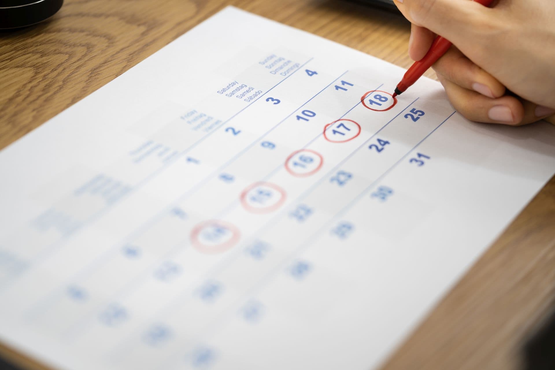 Frau trägt Tage ihrer Menstruation in den Kalender ein