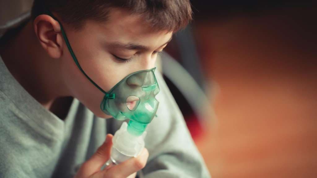 Jugendlicher mit Asthma trägt Beatmungsmaske