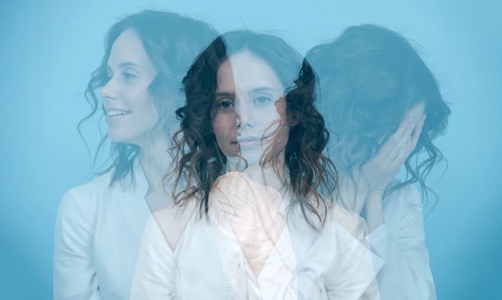 Dynamisches Dreifachbelichtungsporträt einer Frau mit drei verschiedenen Richtungen vor blauem Hintergrund