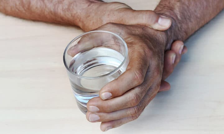 Die Hände eines Mannes mit Parkinson zittern. Stark zitternde Hände eines älteren Mannes