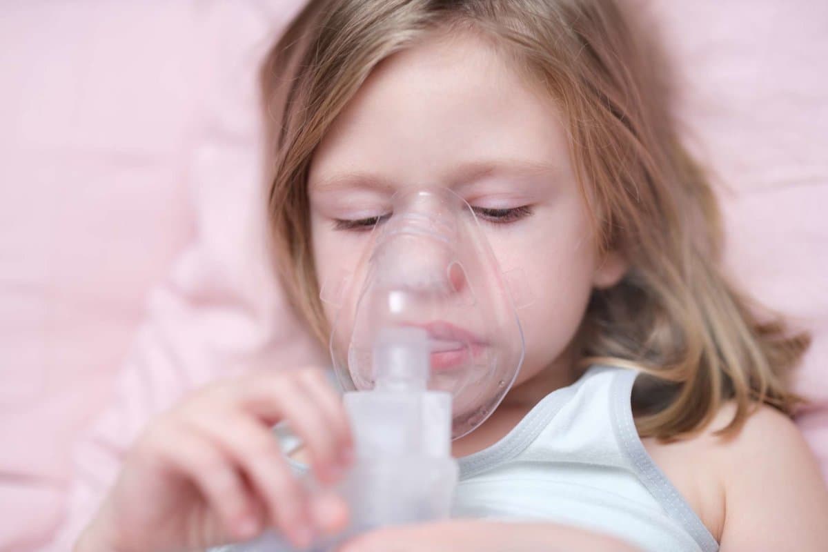 Little girl making inhalation of medicine for cough treatment. Treatment of bronchial asthma in children concept
