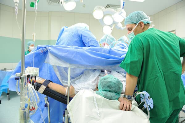 Intervention chirurgicale en salle d'opération avec le patient sur la table d'opération.
