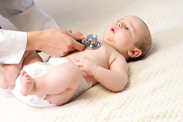 Ärztin hört Lunge eines Babies mit dem Stethoskop ab