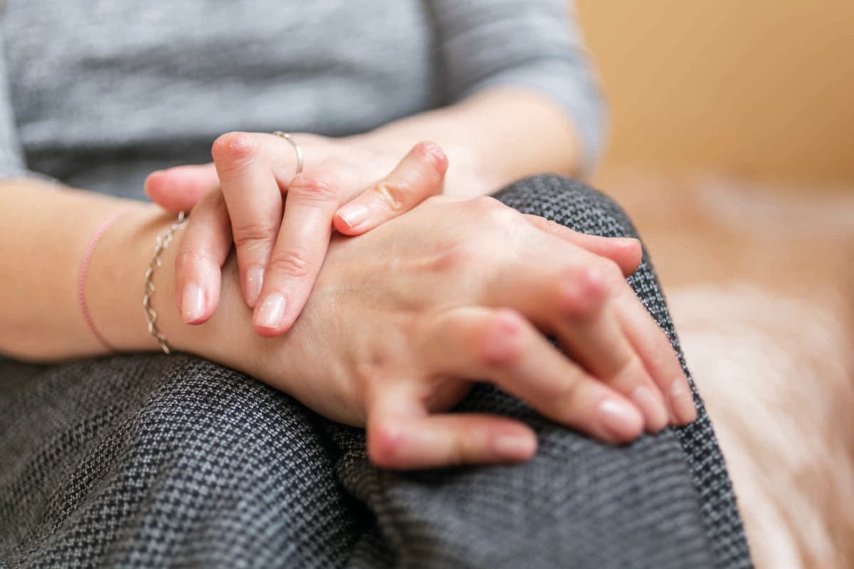 Young woman having rheumatoid arthritis takes a rest sittinng on