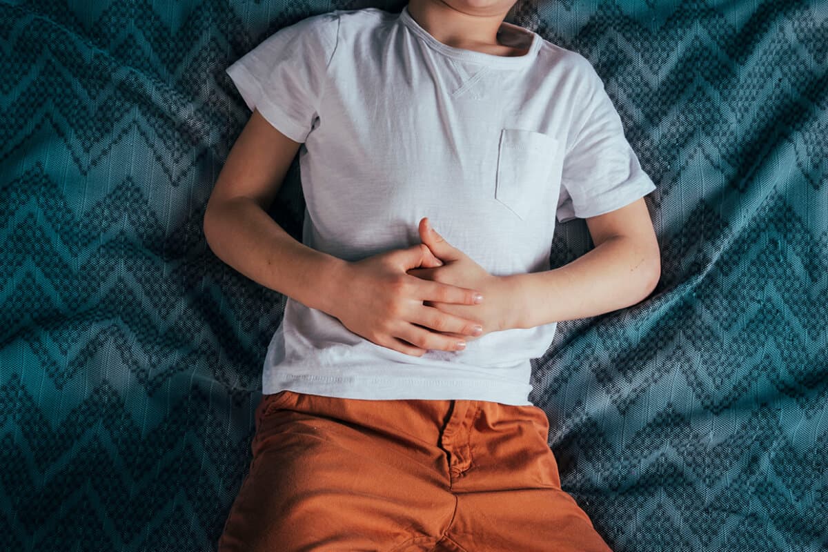 Bauchschmerzen bei einem Vorschulkind. Vergiftung bei Kindern. Der Junge hält seine Hände an die Bauchhöhle
