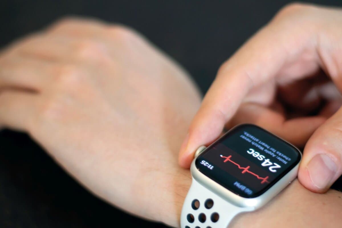 Junger Mann misst seine Herzfrequenz mit einer Apple Watch.