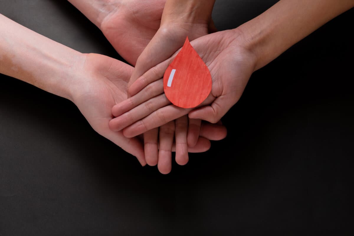 Hands holding a drop of blood, blood donation, blood transfusion, world blood donor day, world hemophilia day concept