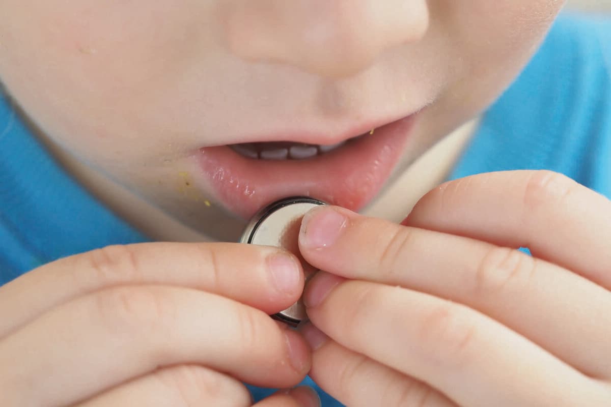 close up coin battery in the child's hands danger of swallowing