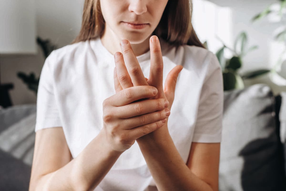 Cropped shot unhealthy female massage hand with wrist pain, rheumatoid arthritis.