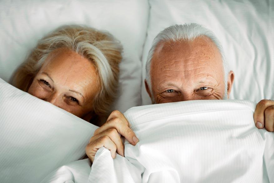 Senior Paar im Bett und Verstecken sich unter der Bettwäsche