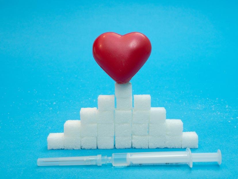 Ein rotes Herz auf mehreren Zuckerwürfel und davor ist eine Spritze